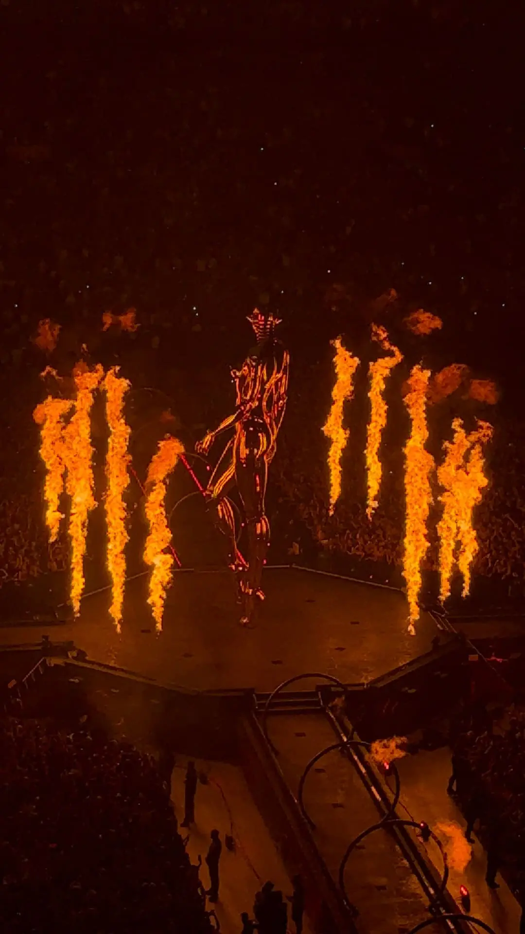 Leuchtende Skelettfigur auf der Bühne umgeben von großen Flammen bei einem Konzert