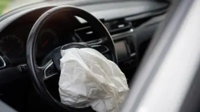 Ausgelöster weißer Airbag im Lenkrad eines Autos