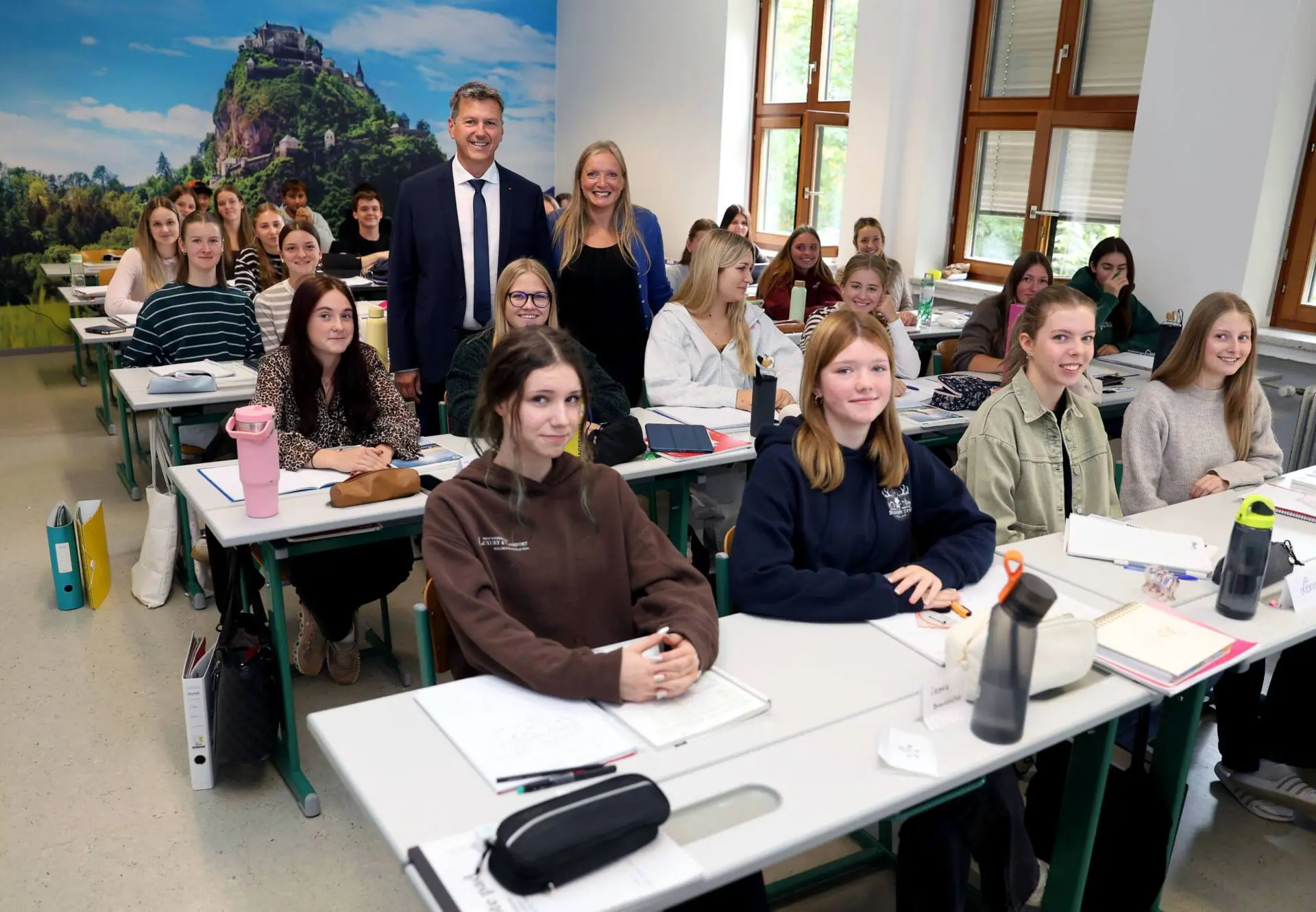 Landeshauptmann Daniel Fellner und Direktorin Johanna Michenthaler stehen mit einer Klasse im Unterrichtsraum.