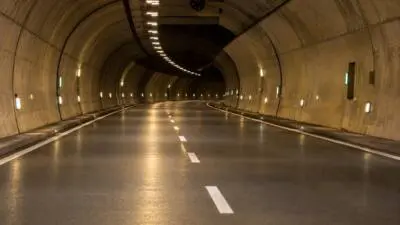 Leere, beleuchtete Fahrbahn in einem geschwungenen Straßentunnel