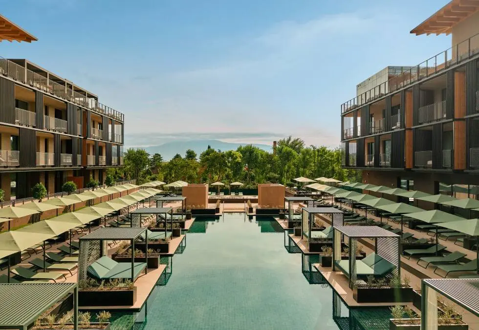 Innenhof des Falkensteiner Resorts mit Pool, Liegen und modernen Gebäuden