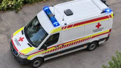 Ein Rettungswagen des Österreichischen Roten Kreuzes mit eingeschaltetem Blaulicht auf einer Straße