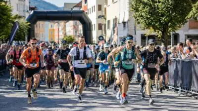 Ultraläufer mit Startnummern und Trinkwesten laufen durch die Schwazer Altstadt.