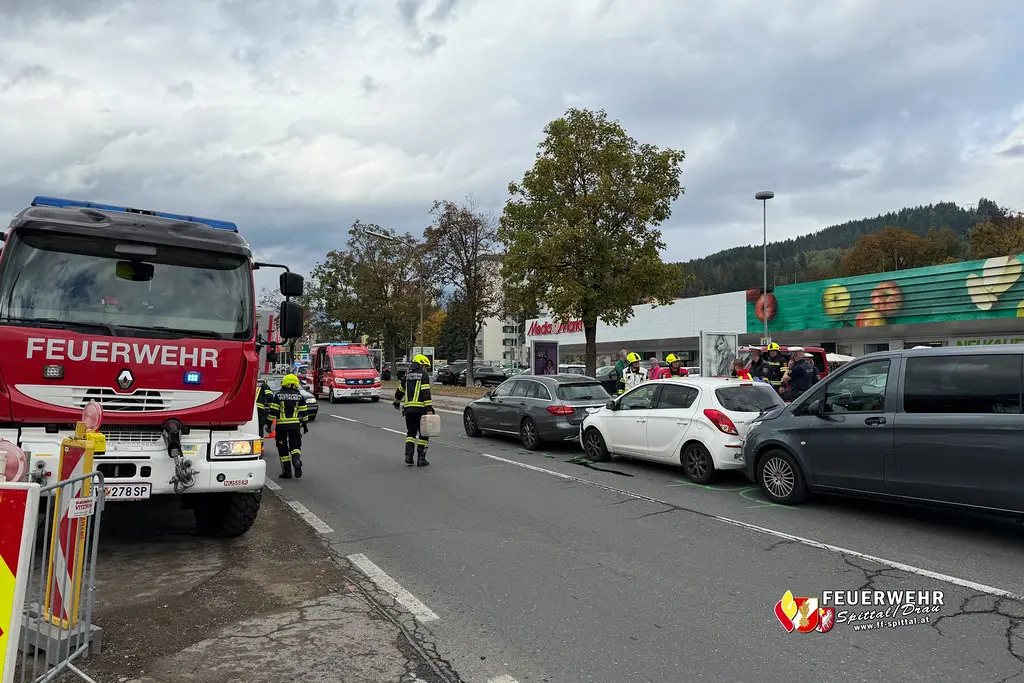 Feuerwehrkräfte stehen neben Einsatzfahrzeugen und Autos auf der Villacher Straße in Spittal.