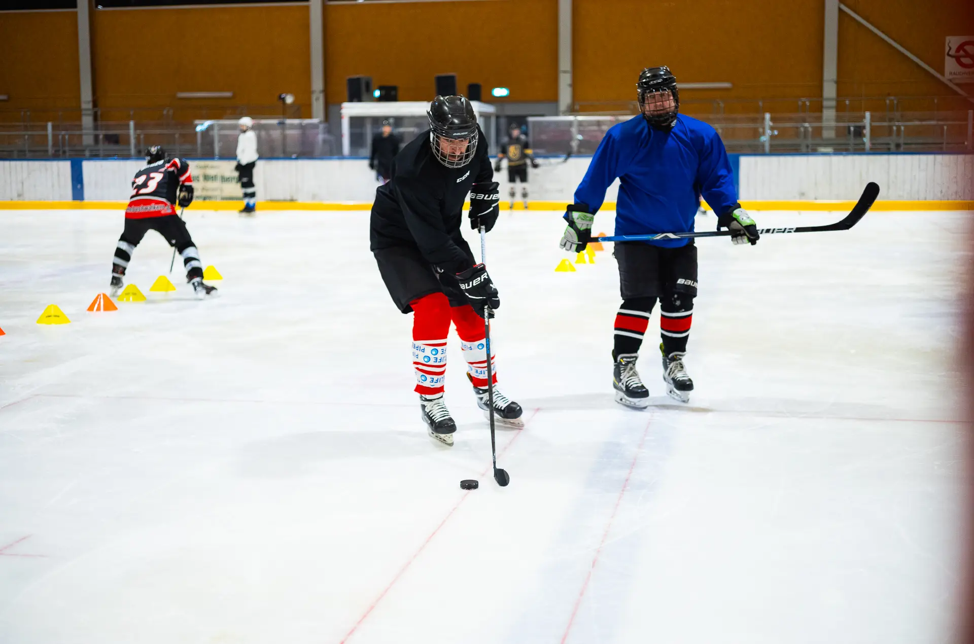 Eishockeyspieler trainieren auf dem Eis mit Schlägern und Puck.