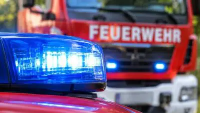 KI-generiertes Bild: Ein blaues Blaulicht vor einem roten Feuerwehrfahrzeug.