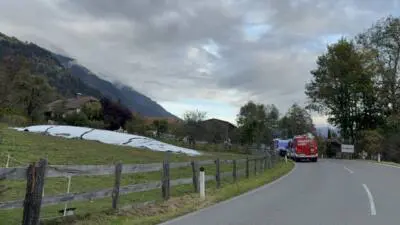 Ein Feuerwehrfahrzeug und ein weiteres Fahrzeug stehen auf der Straße in Radlach.