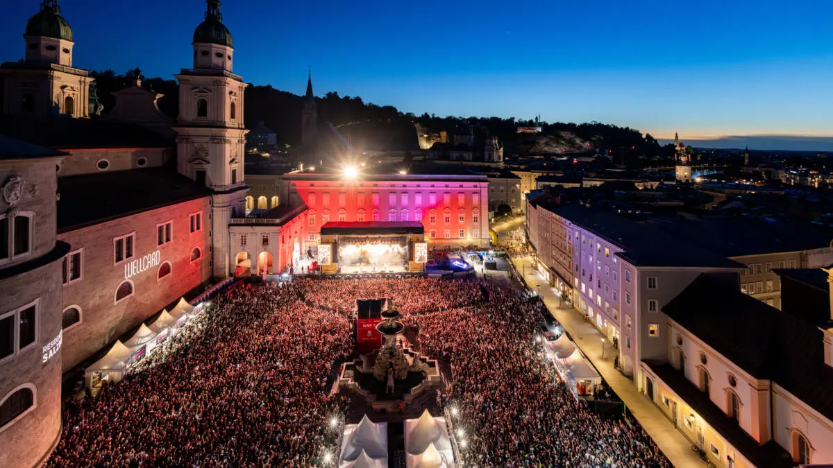 Konzertpublikum vor einer beleuchteten Bühne am Residenzplatz in Salzburg
