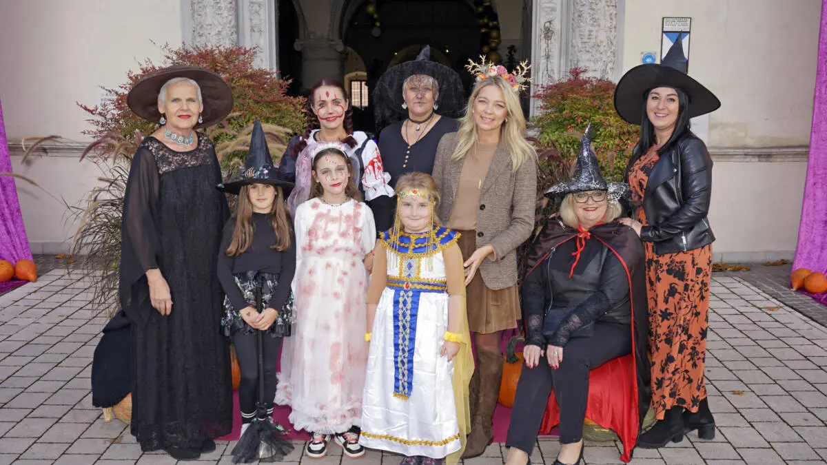 Verkleidete Erwachsene und Kinder stehen vor dem Eingang von Schloss Porcia.