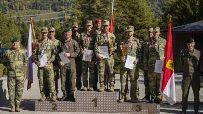 Uniformierte Soldaten mit Medaillen und Urkunden auf einem Siegerpodest