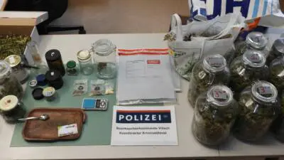 Gläser mit getrocknetem Pflanzenmaterial, Waage und Schild des Bezirkspolizeikommandos Villach