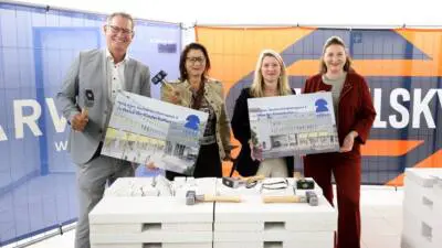 Vertreterinnen und Vertreter zeigen Baupläne beim Umbauauftakt für das Haus für Kinderkultur