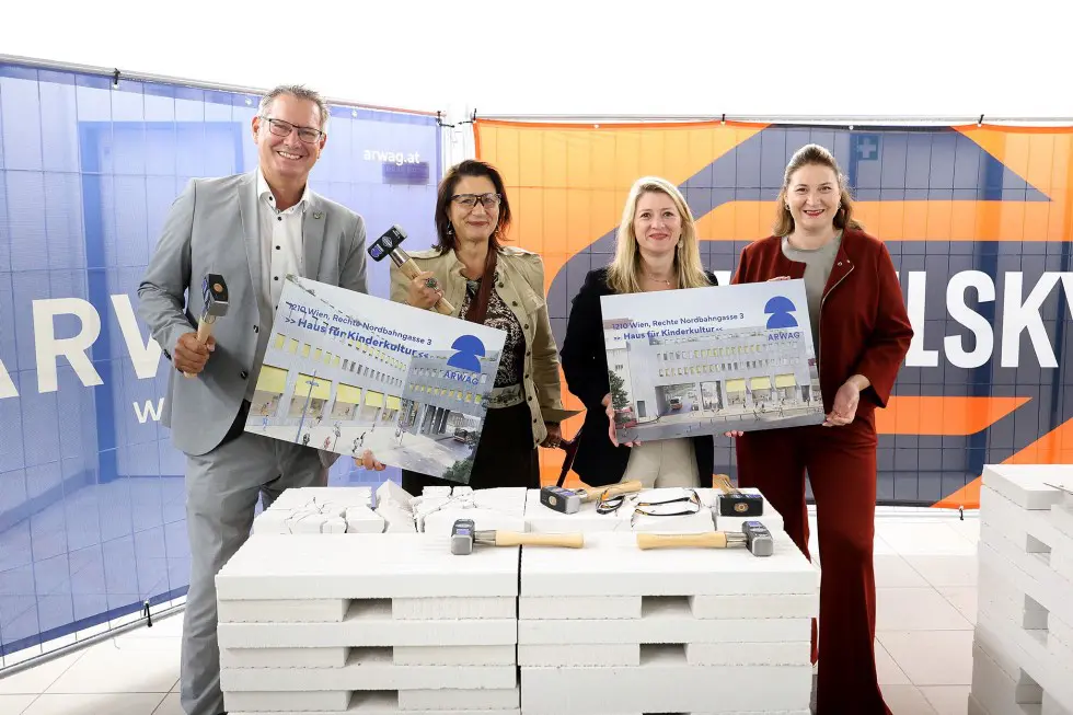 Vertreterinnen und Vertreter zeigen Baupläne beim Umbauauftakt für das Haus für Kinderkultur