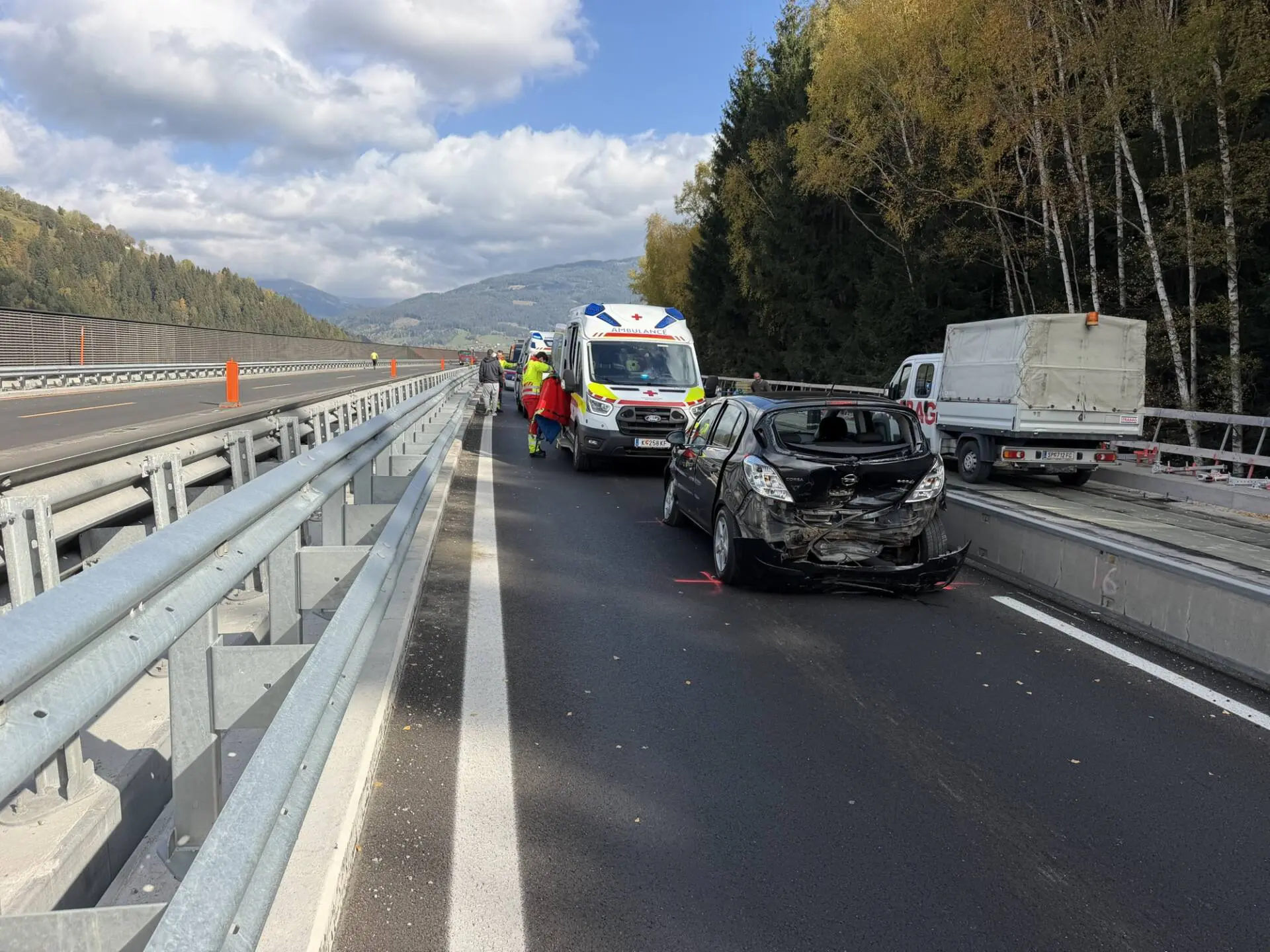 Beschädigter Pkw und Rettungswagen auf einer Autobahnbaustelle