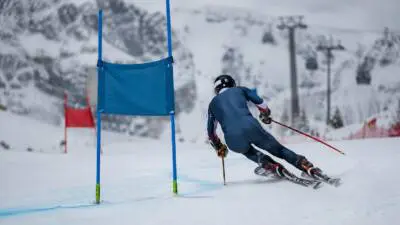 KI-Symbolbild: Ein Skifahrer fährt auf verschneiter Piste an einem blauen Tor vorbei.