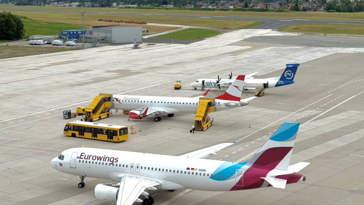 Eurowings-Flugzeug auf dem Vorfeld eines Flughafens vor einer Bergkulisse