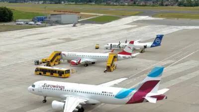 Eurowings-Flugzeug auf dem Vorfeld eines Flughafens vor einer Bergkulisse