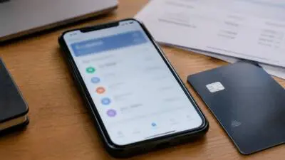 KI-generiertes Bild: Ein Smartphone mit unscharfer App-Anzeige liegt neben einer Karte auf einem Holztisch.