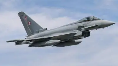 KI-generiertes Bild: Ein grauer Kampfjet fliegt vor wolkigem Himmel.