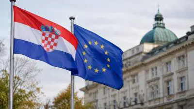 KI-generiertes Bild: Kroatische und europäische Flaggen wehen vor einer Gebäudefassade mit Kuppel.