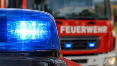 KI-Symbolbild: Blaues Blaulicht vor einem roten Feuerwehrfahrzeug.