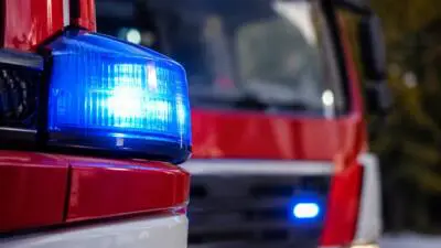 KI-Symbolbild: Nahaufnahme eines roten Einsatzfahrzeugs mit blauem Warnlicht.