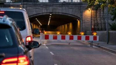 KI-generiertes Bild: Eine rot-weiße Straßensperre versperrt die Zufahrt zu einem Tunnel.
