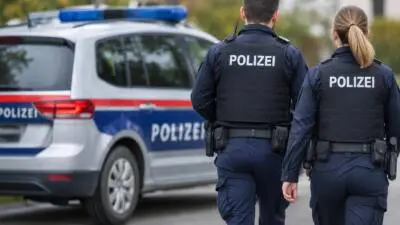 KI-generiertes Bild: Zwei Polizeikräfte stehen neben einem blau-weißen Polizeiauto.