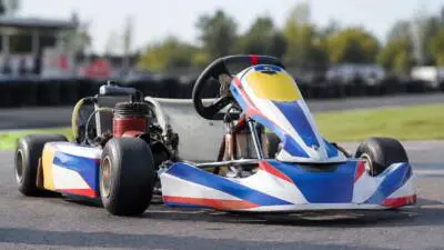 KI-Symbolbild: Ein blau-weiß-rotes Kart mit gelben Akzenten auf einer Rennstrecke.