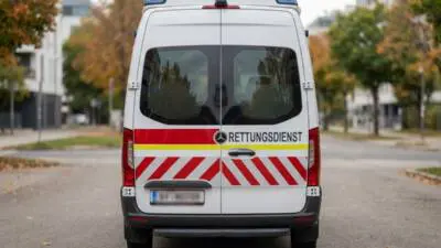 KI-generiertes Bild: Ein weißer Rettungsdienstwagen steht auf einer Straße.