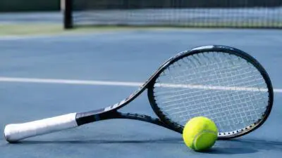 KI-Symbolbild: Ein Tennisschläger und ein gelber Ball liegen auf einem blauen Tennisplatz.