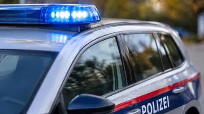 KI-generiertes Bild: Ein silber-blaues Polizeiauto mit leuchtendem Blaulicht.