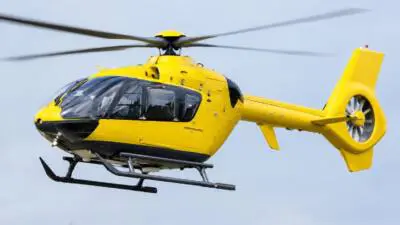 KI-generiertes Bild: Ein gelber Hubschrauber fliegt vor hellem Himmel.
