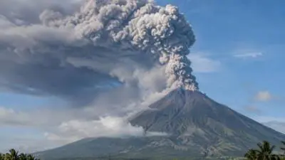 KI-generiertes Bild: Ein Vulkan stößt eine graue Aschewolke in den Himmel.