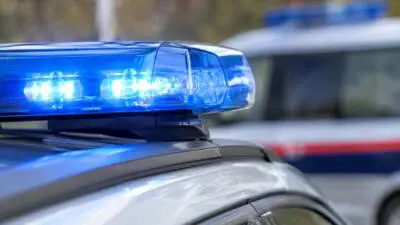 KI-generiertes Bild: Ein blaues Warnlicht auf dem Dach eines grauen Autos.