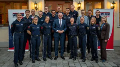 Polizeisportlerinnen und Polizeisportler stehen für ein Gruppenfoto vor einem Gebäude.