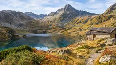 KI-generiertes Bild: Ein Bergsee liegt vor felsigen Gipfeln, daneben steht eine steinerne Hütte.