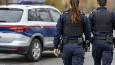 KI-generiertes Bild: Uniformierte Personen neben einem weißen Fahrzeug mit blau-roten Streifen.