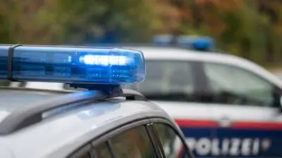KI-generiertes Bild: Eine blaue Signalleuchte auf einem weißen Fahrzeug vor unscharfem Hintergrund.