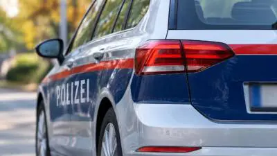 KI-generiertes Bild: Nahaufnahme eines blau-weißen Polizeiautos mit rotem Streifen.
