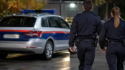 KI-Symbolbild: Uniformierte Personen stehen neben einem silbernen Kombi mit Blaulichtbalken.