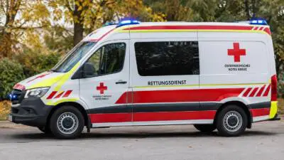 KI-Symbolbild: Ein weiß-roter Rettungswagen mit Rotkreuz-Kennzeichnung steht auf einer Straße.