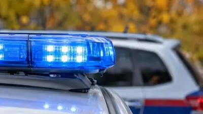 KI-Symbolbild: Ein blaues Blaulicht auf dem Dach eines weißen Fahrzeugs.