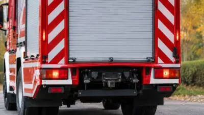 KI-generiertes Bild: Rückansicht eines rot-weißen Feuerwehrfahrzeugs mit geschlossenem Rollladen.