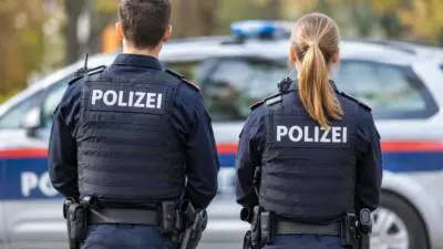 KI-generiertes Bild: Polizeikräfte in dunklen Uniformen vor einem weiß-blauen Polizeiauto.