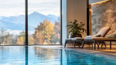 KI-generiertes Bild: Ein Innenpool mit Ruheliegen und Blick auf Berge.