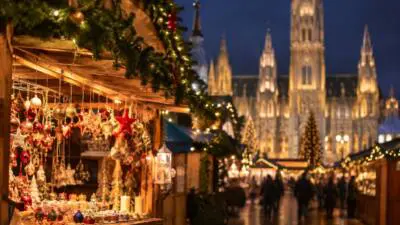 KI-generiertes Bild: Ein beleuchteter Marktstand mit Weihnachtsschmuck vor einer Kirche.