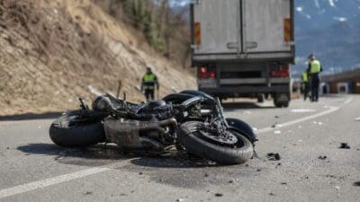 Umgestürztes Motorrad liegt nach Unfall mit Lkw auf der Straße