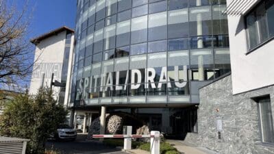 Runde Glasfassade des Krankenhauses Spittal an der Drau mit großem Schriftzug SPITTAL/DRAU