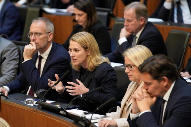 Abgeordnete mit blonden Haaren gestikuliert während einer Debatte im Nationalrat